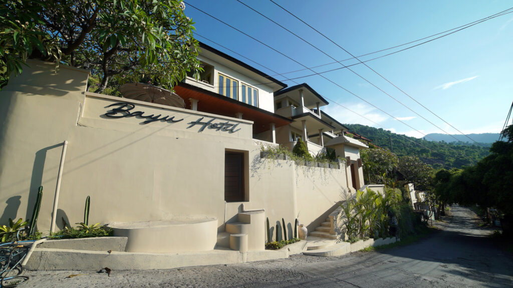 Exterior of Bayu Hotel Lipah Beach with tropical hills in the background.